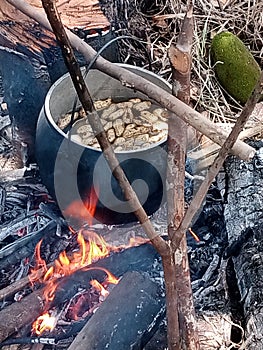 A pot of peanuts being boliled using firewood