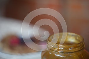Pot of pouring honey on brown background photo