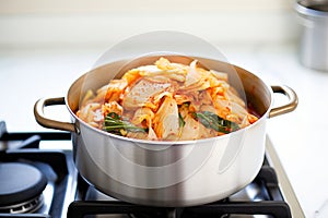 a pot of simmering kimchi on a stovetop