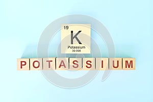 Potassium chemical element symbol with atomic mass and atomic number in wooden blocks flat lay composition.