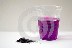 Potassium permanganate powder on a white background.