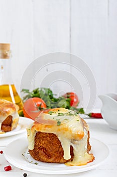 Potato balls with minced meat in deep fat, baked with mozzarella.