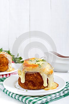 Potato balls with minced meat in deep fat, baked with mozzarella.