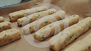 Potato cheese sticks lie on a baking sheet