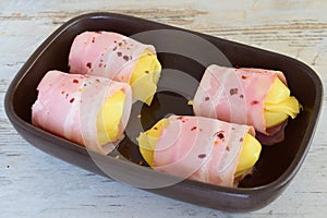 Potato with cheese wrapped in bacon in a ceramic form