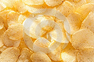 Potato chips background in the sunlight.