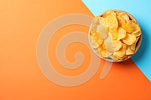 Potato chips. Beer snacks on two tone background