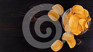 Potato chips in bowl on a wooden background top view