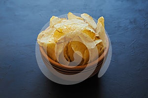 Potato chips on dark blue background.