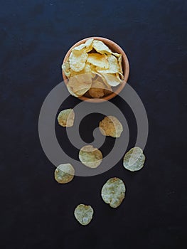 Potato chips on dark blue background.