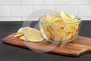 Potato chips in a glass bowl on a table.  Macro view