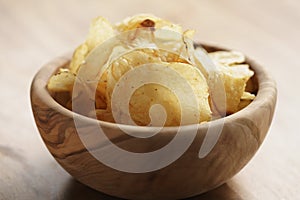 Potato chips with herbs in wood bowl