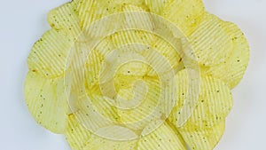 Potato chips macro white background. Unhealthy junk food closeup rotating.