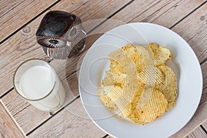 Potato chips with milk on wooden backgrounds