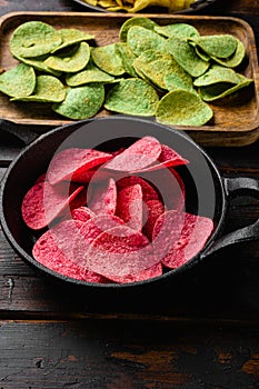 Potato chips pink colored on old dark  wooden table background