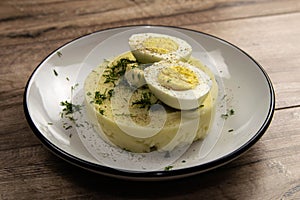 Potato food . Ingredients for mashed potatoes - eggs, milk, butter and potatoes on wooden background