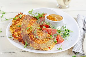 Potato fritters or pancakes served with sauce. European cuisine.