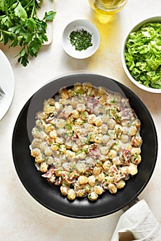 Potato gnocchi with bacon in pan