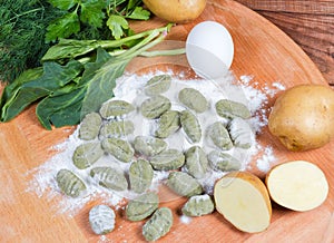 Potato gnocchi with spinach being prepared among the ingredients closeup photo