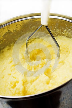 Potato mash with masher. photo