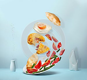 Potato pancake , salad, pieces of baguette and fried egg in levitation
