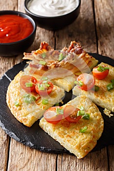 potato pancakes with bacon, tomatoes, onions and sauces close-up. vertical