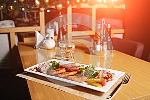 Potato pancakes with bacon on a white rectangular plate on a table in a restaurant. Table setting at the restaurant