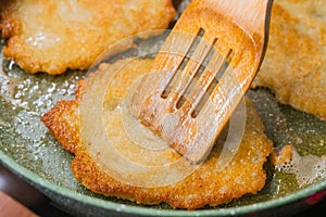 Potato pancakes on ceramic green frying pan