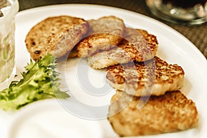 Potato pancakes or draniki or latkes on a plate in a restaurant. Traditional potato dish and food in Eastern Europe and