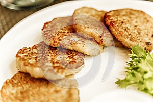 Potato pancakes or draniki or latkes on a plate in a restaurant. Traditional potato dish and food in Eastern Europe and