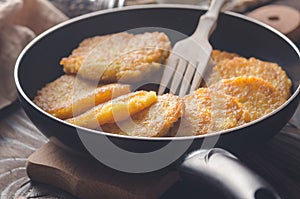 Potato pancakes in a frying pan.