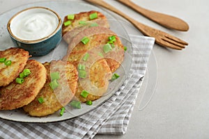 Potato pancakes or latkes or draniki with sour cream in plate