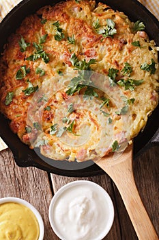 Potato pancakes with sauce close-up on a frying pan. vertical to