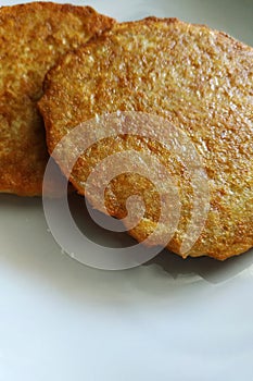 Potato pancakes on a white plate  fatty and unhealthy food  high-calorie and delicious dish