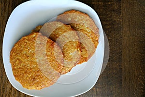 Potato pancakes on a white plate, fatty and unhealthy food, high-calorie and delicious dish