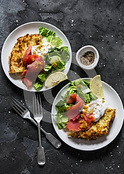 Potato roasted tortilla with greek yogurt, smoked salmon and green salad on dark background, top view. Delicious breakfast,