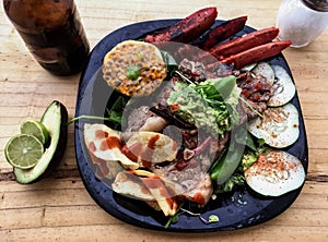 Potato salad with barbecue dry aged sliced fillet steak and herbs on wood