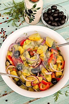 Potato salad with onion, olives, pepper, pickled cucumber and dill