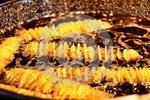 Potato spirals in boiling oil at a street stall