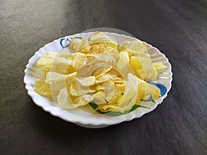 Potatochips in a plate, blackbackground