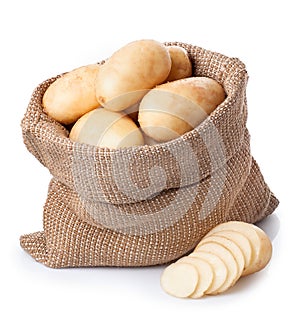 potatoes in burlap bag with sliced potato beside isolated on white