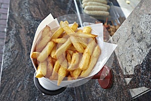 Potatoes fries in a little white paper bag