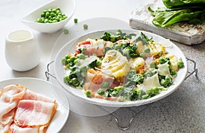 Potatoes gnocchi, green peas, shinach abd bacon  on white  plate close up