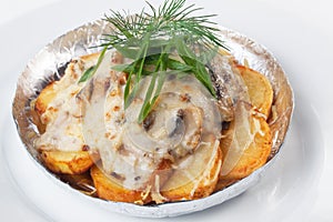 Potatoes with mushrooms in foil white background mayonnaise cheese