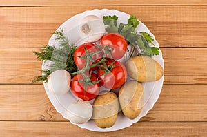 Potatoes, onion, ripe tomatoes, parsley and dill in dish