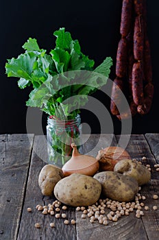 Potatoes, onions, chickpeas, turnip greens and chorizos on a woo