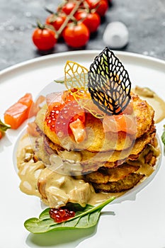 Potatoes pancakes fried with red caviar, red fish and mushroom sauce. vertical image. top view. place for text