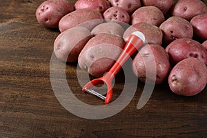 Potatoes with peeler photo