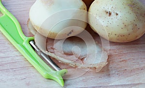 Potatoes, Peelings and Peeler. photo