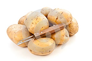 Potatoes with potato peeler photo